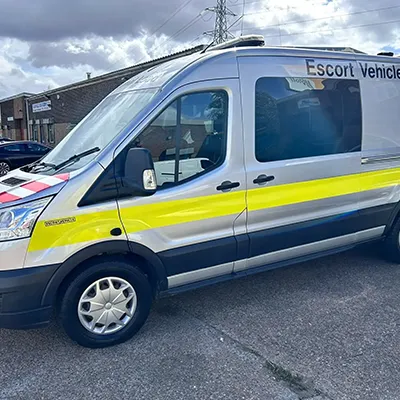 A yellow and blue van parked in a parking lot.