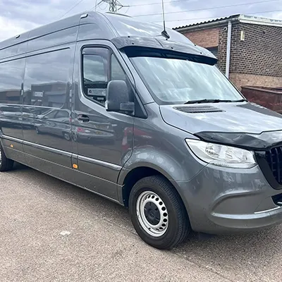 A grey van parked in a parking lot.